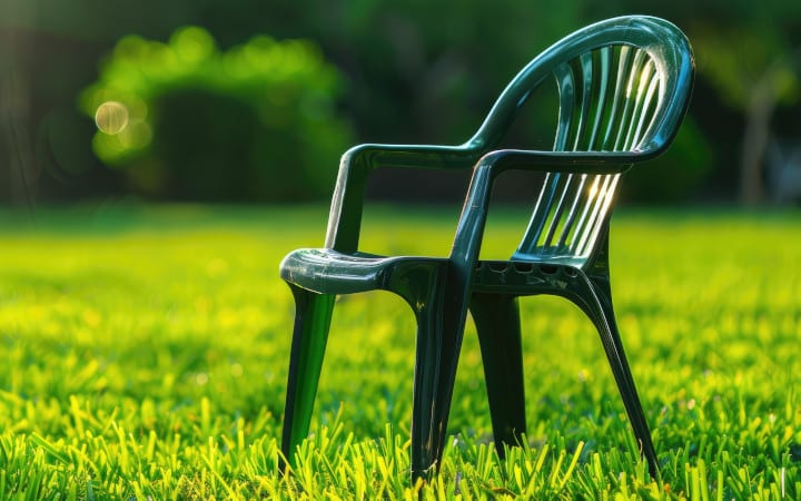 Chaise en plastique verte d'un salon de jardin dont a couleur a été ravivée après qu'elle ait été ternie par le soleil